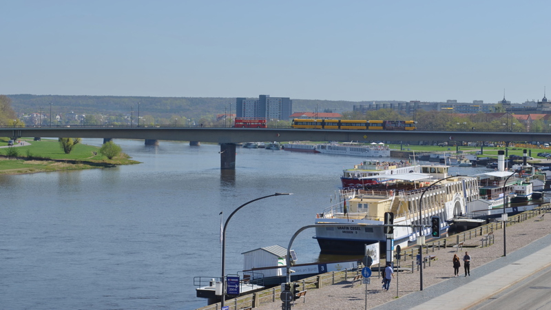 22 - The Carola Bridge (Carolabrücke) spanning the Elbe River in Dresden, Germany, alongside passenger paddle steamers moored at the riverbank